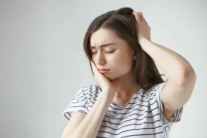 woman-closing-eyes-touching-cheek-back-her-head-while-suffering-from-terrible-tooth-ache