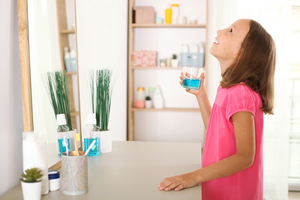 child-is-rinsing-mouth-with-mouthwash-oral-health-children